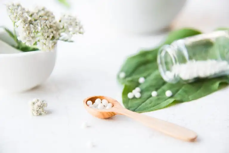 homeopathic granules, medicinal herbs on a natural wooden table on a natural background. alternative medicine and homeopathy