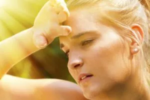 Woman outside, in the heat being affected by the temperature and the sun.