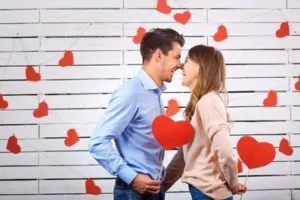 Man and woman with hearts on a white board background. Concept Valentine's Day.