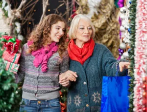 Happy mother and daughter shopping for Christmas ornaments in store