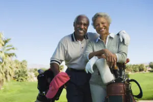 Portrait of happy senior couple in golf course smiling