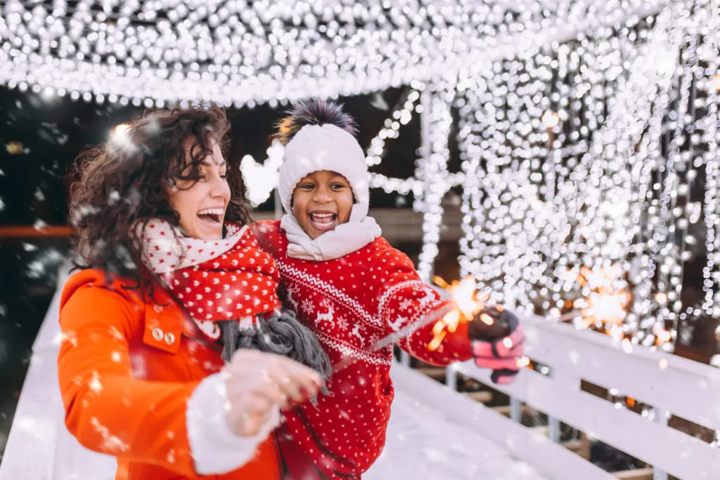Little black girl enjoying in ice skating with her mother.