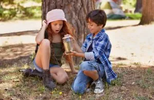 Children, outdoors and nature with bugs in jar on school trip, summer camping and adventure for fun learning. Girl, boy and smile in forest together with insects in glass, siblings and discover