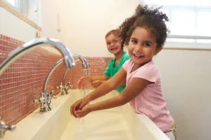 Pupils At Montessori School Washing Hands In Washroom