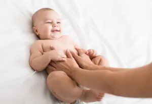 Masseur massaging tummy of baby during colic