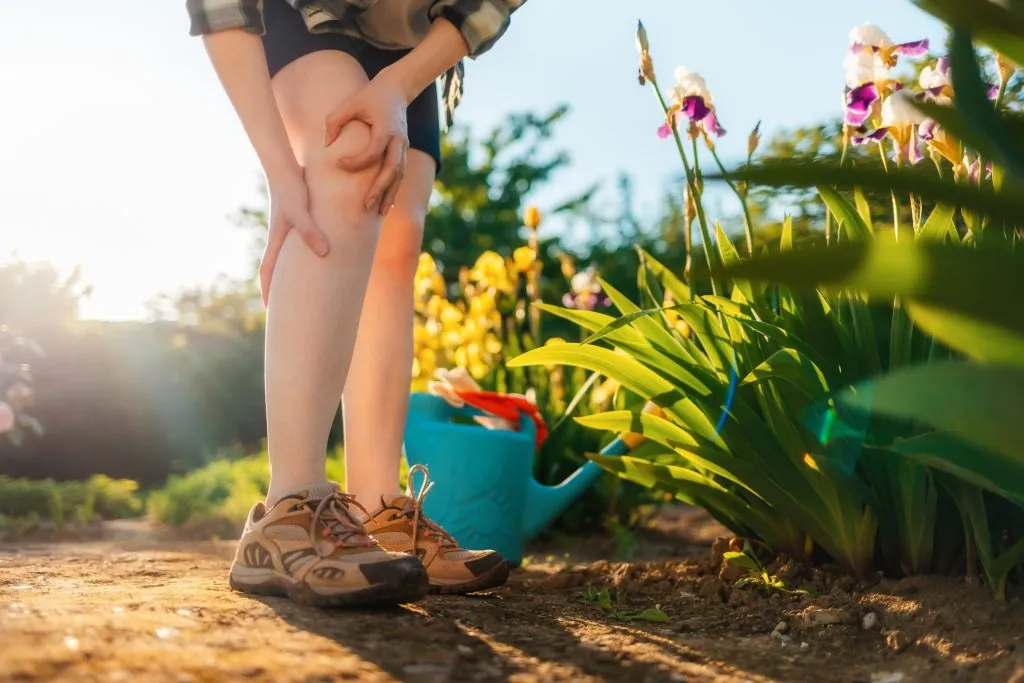 Person holding leg from aches and pain