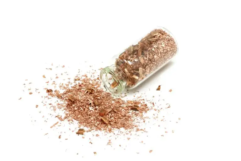 copper metal powder in a glass flask on a white background