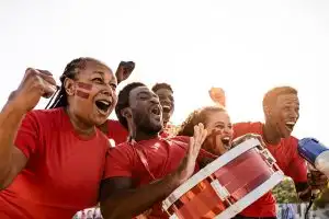 African football fans having fun cheering their favorite team – Soccer sport entertainment concept